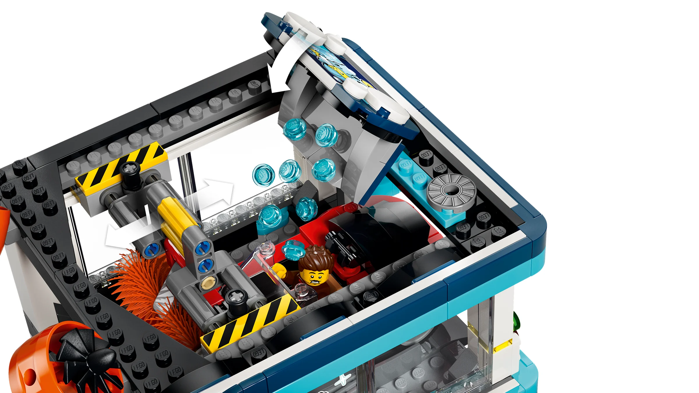 Interiorul spălătoriei auto LEGO, cu o minifigurină în mașină și perii rotative. O experiență detaliată.