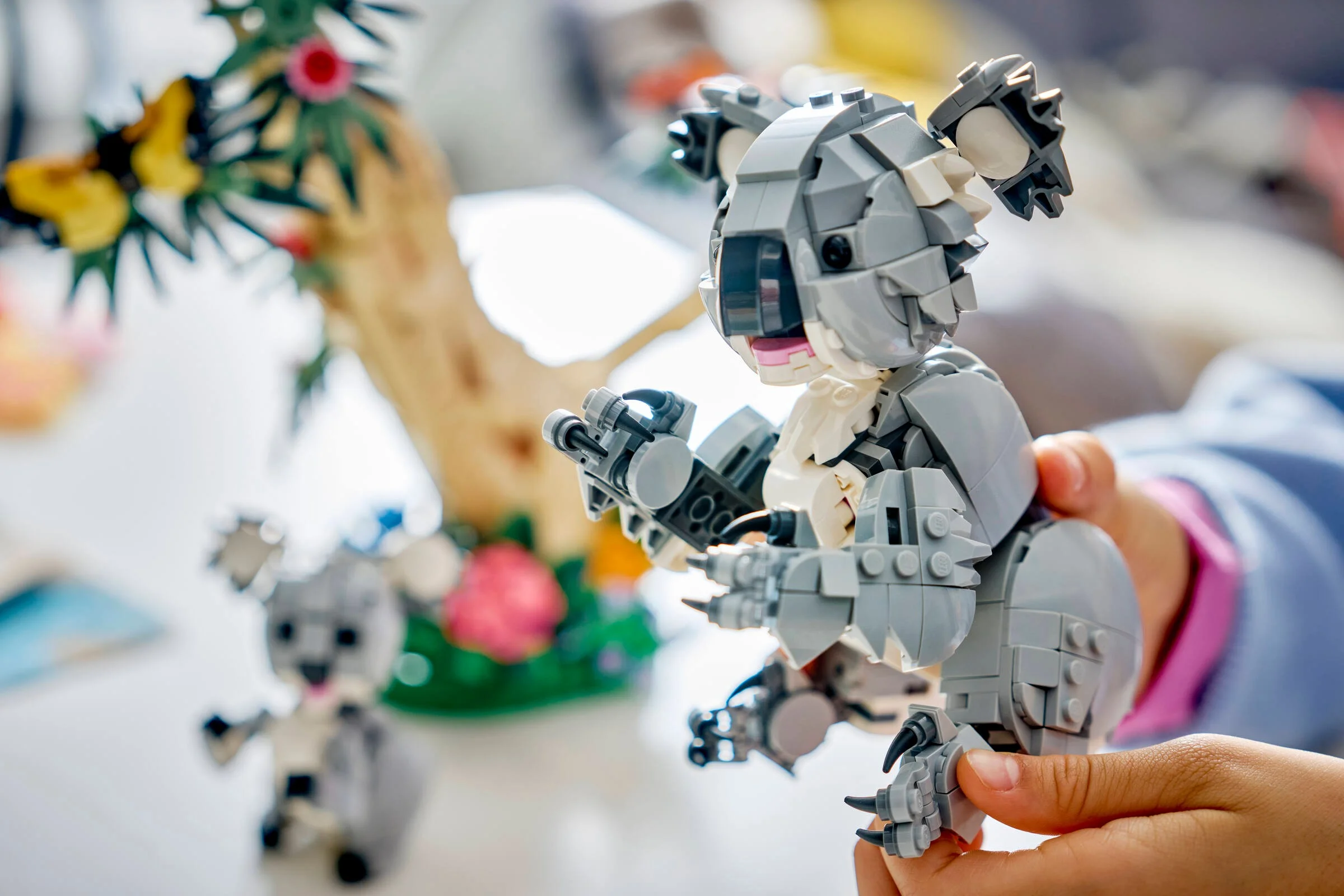 Coala LEGO ținută în mână, detaliind designul și texturile. Aspect interactiv.