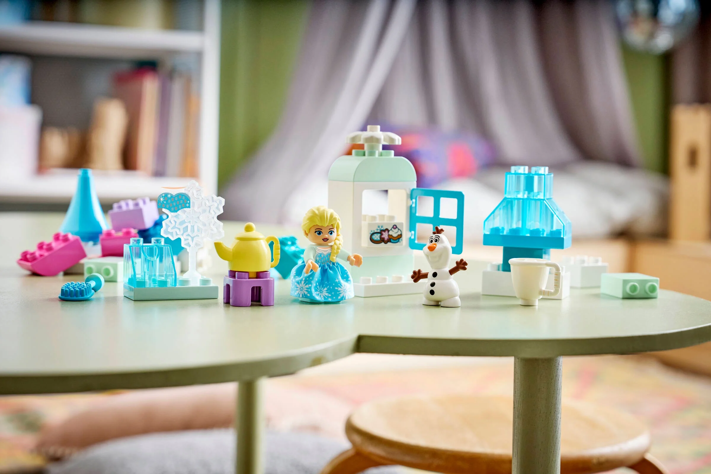 Imagine cu setul LEGO DUPLO Frozen, prezentând minifigurinele Elsa și Olaf și diverse construcții.
