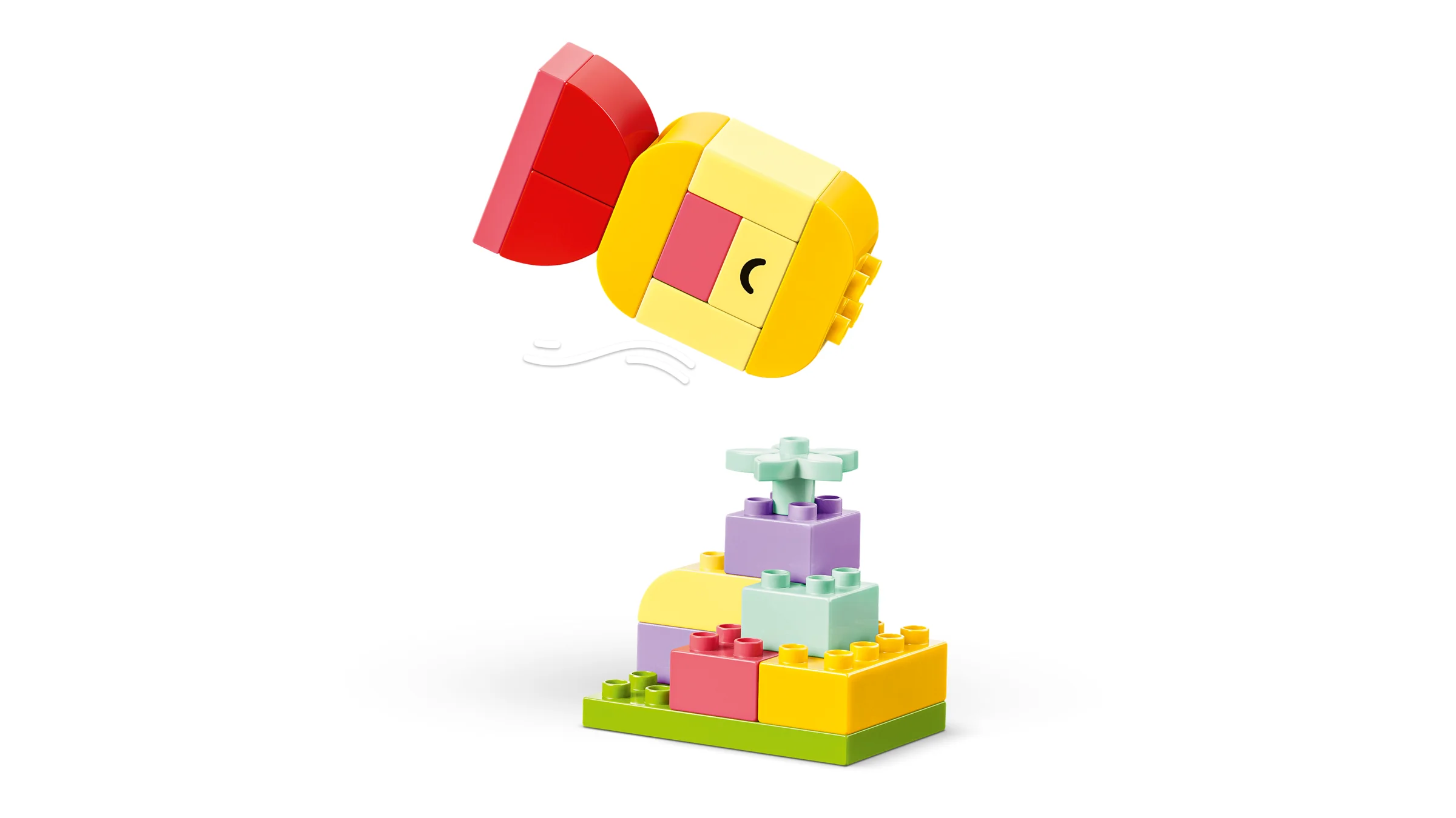 Imagine cu o construcție colorată DUPLO: o turturică zburătoare și o clădire abstractă dedesubt.