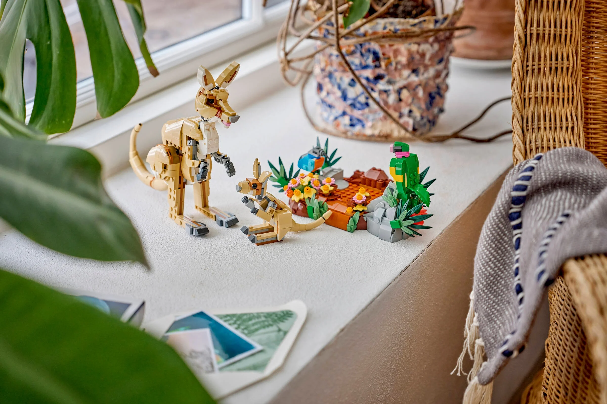 Familie de koala LEGO Creator pe un pervaz luminos, cu plante și decor.