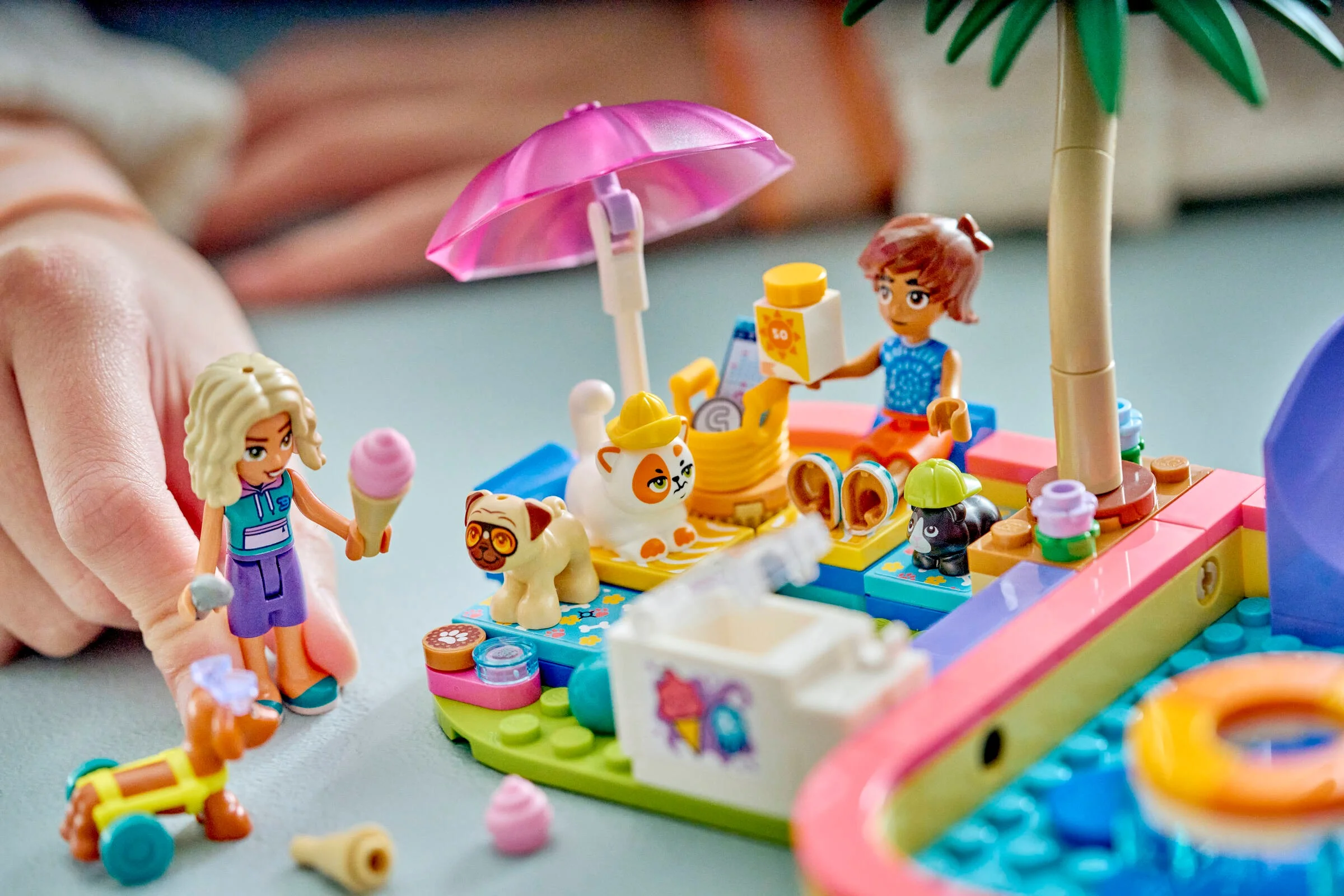 Prim-plan cu setul LEGO Friends 42676, ilustrând mini-păpuși și animale de companie la un parc acvatic distractiv.