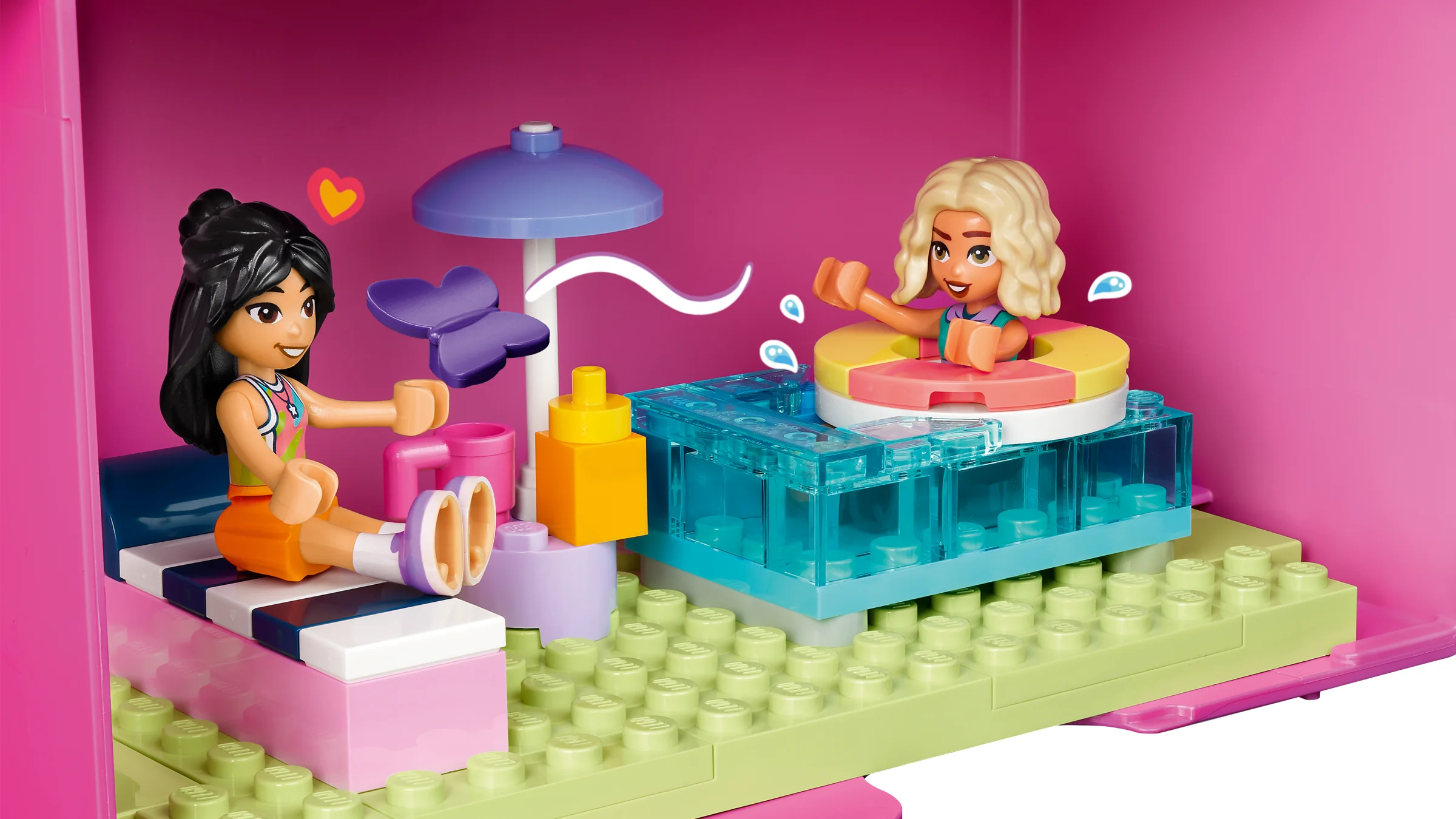 Imagine cu două minifigurine LEGO Friends într-o valiză-căsuță roz. Detaliu interior.