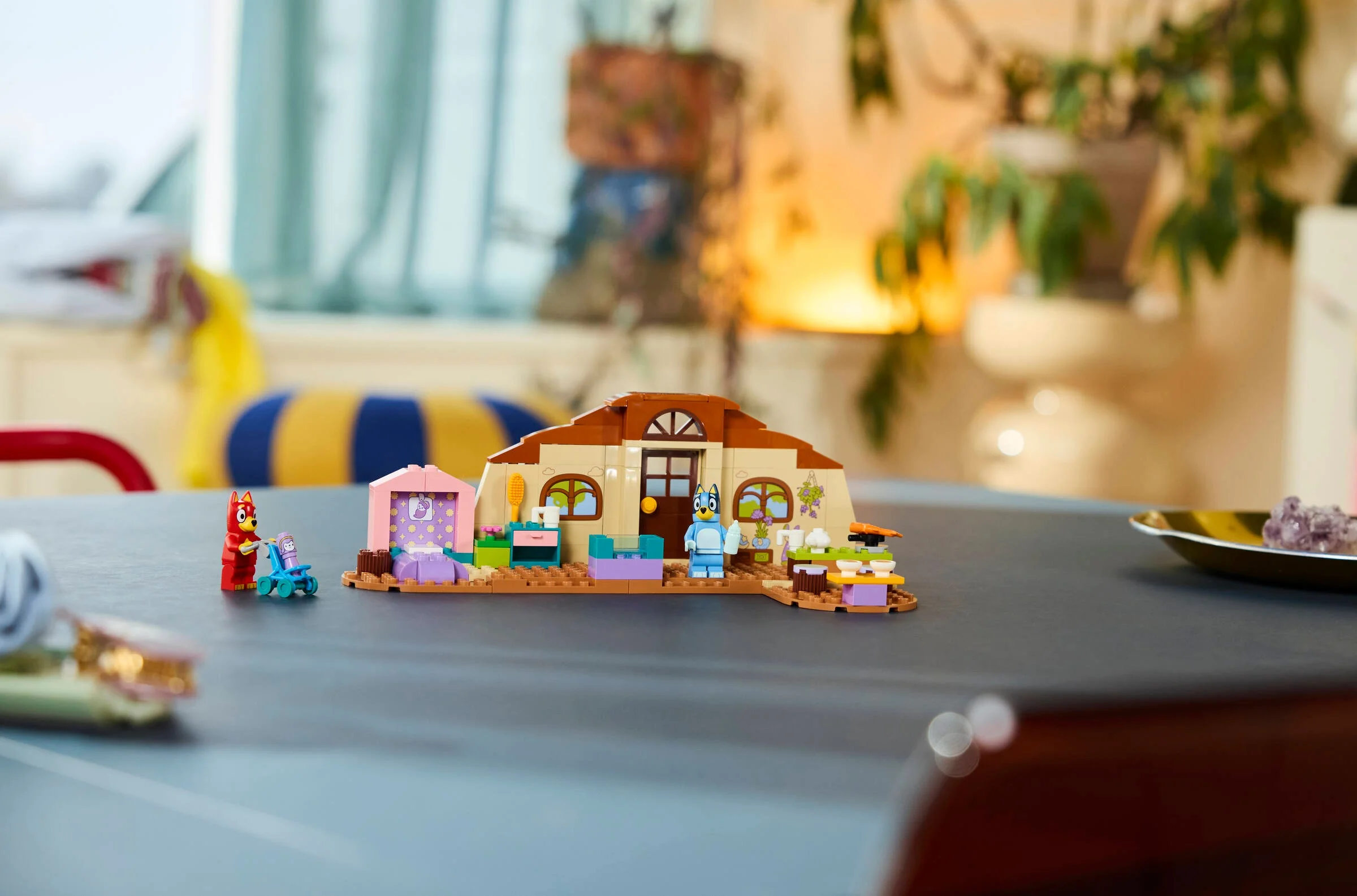 Prezentare cu setul LEGO Bluey, incluzând casa, figurinele Rusty și Bluey, și accesorii.