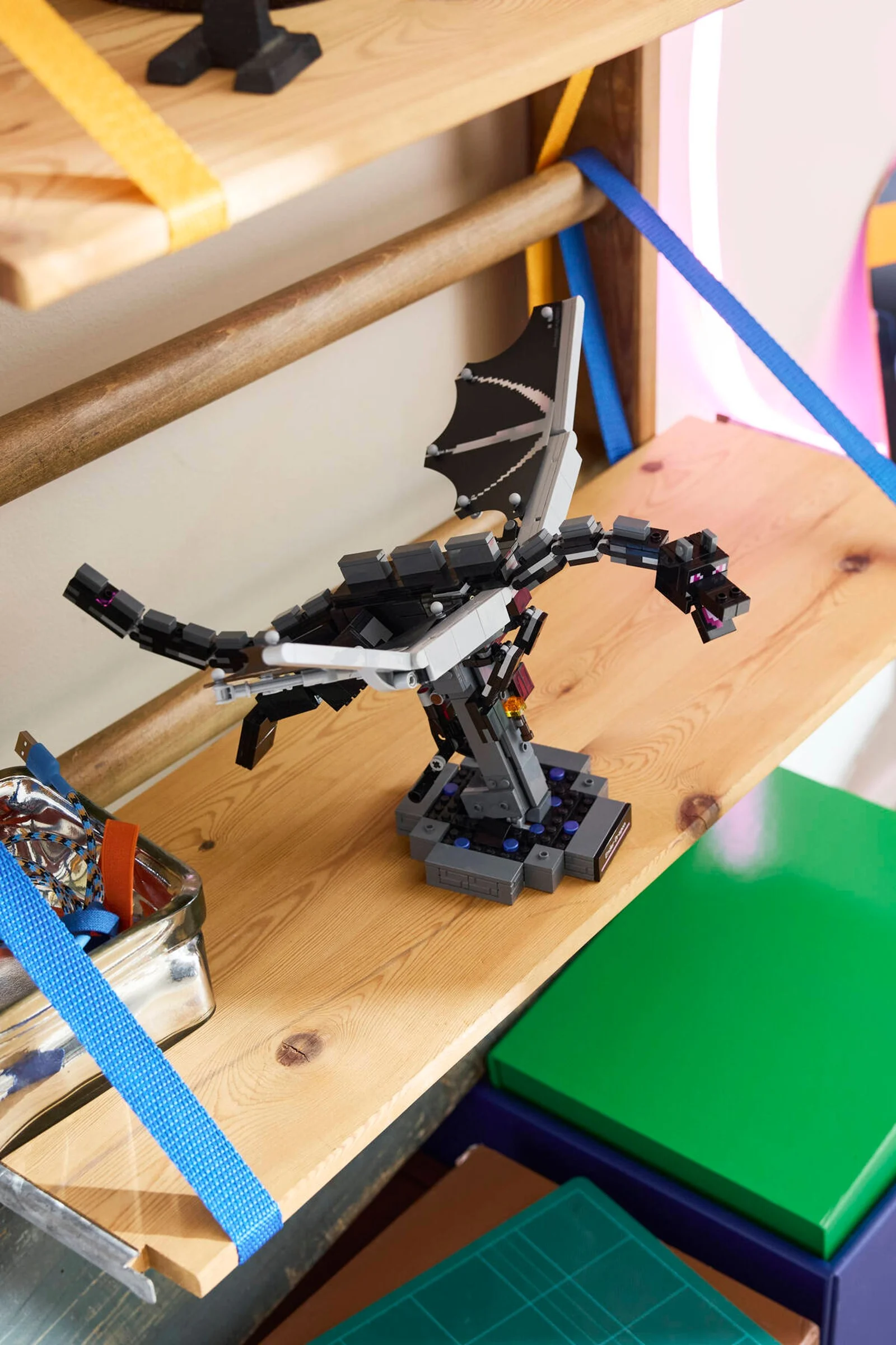 Ender Dragon din LEGO Minecraft pe un raft de lemn. Model detaliat, viu colorat.