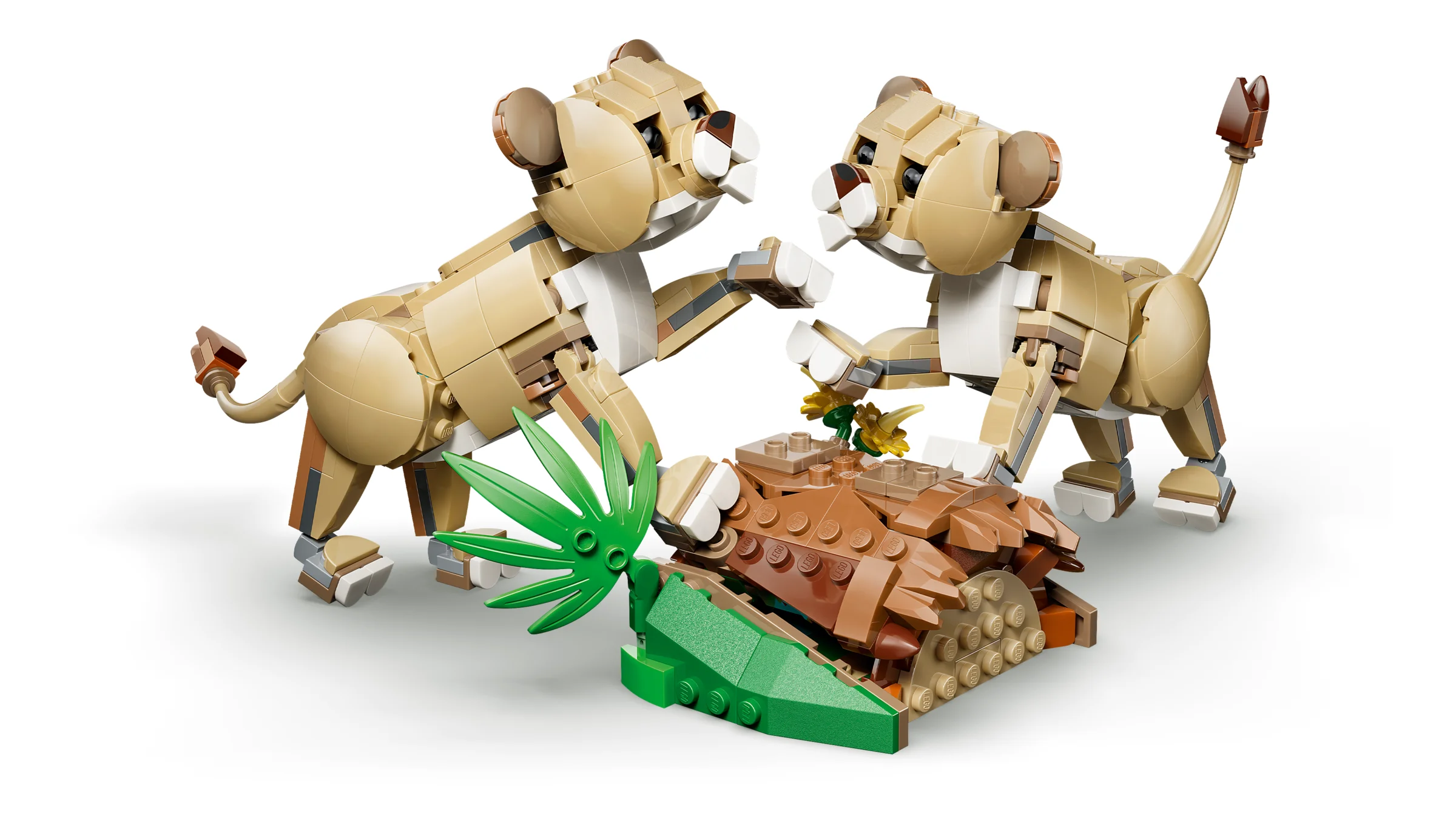Imagine cu doi pui de leu LEGO și un butuc cu plante verzi.