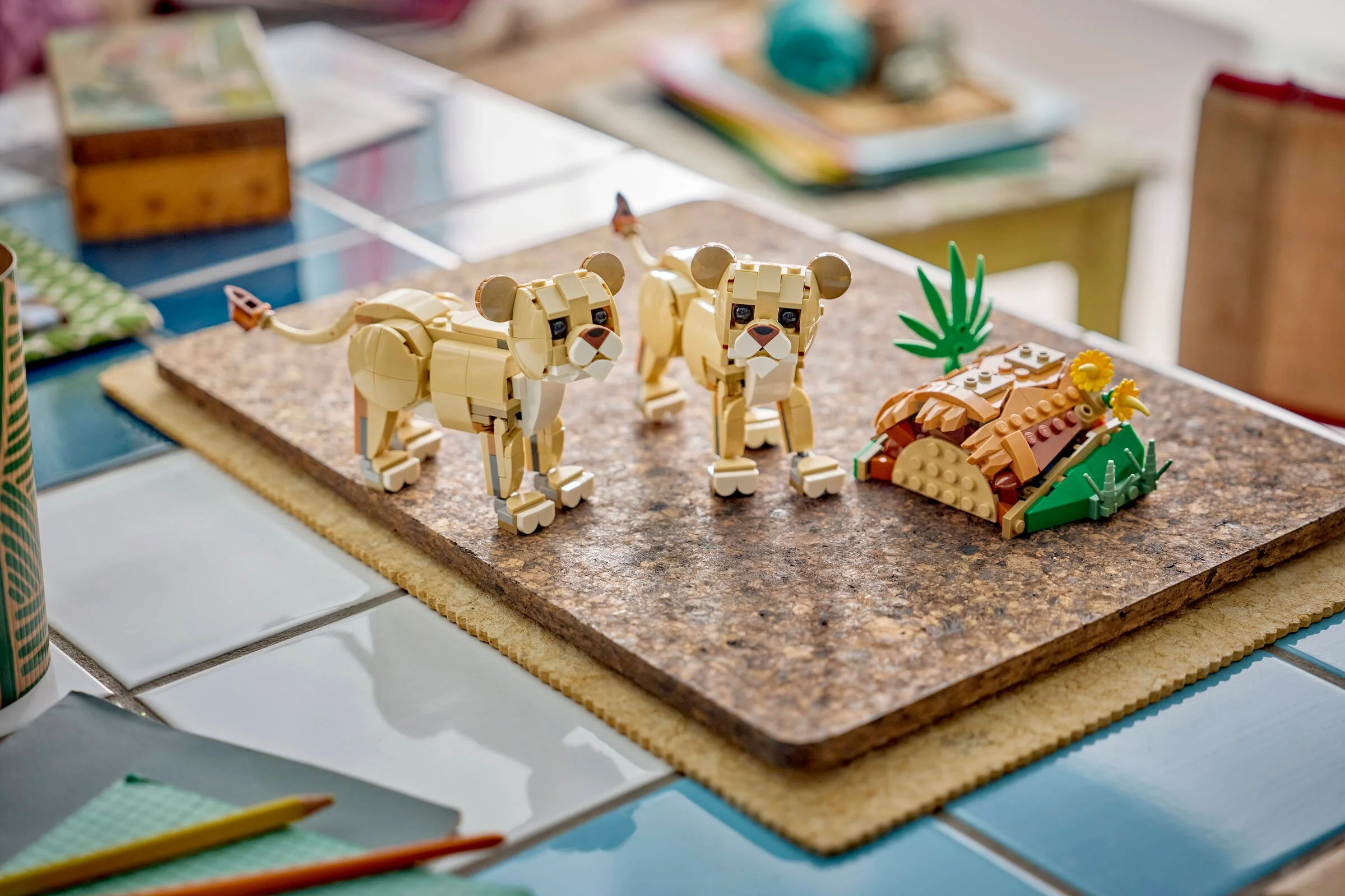 Două figurine leuțe LEGO stând lângă o movilă cu vegetație. Scene pitorească.