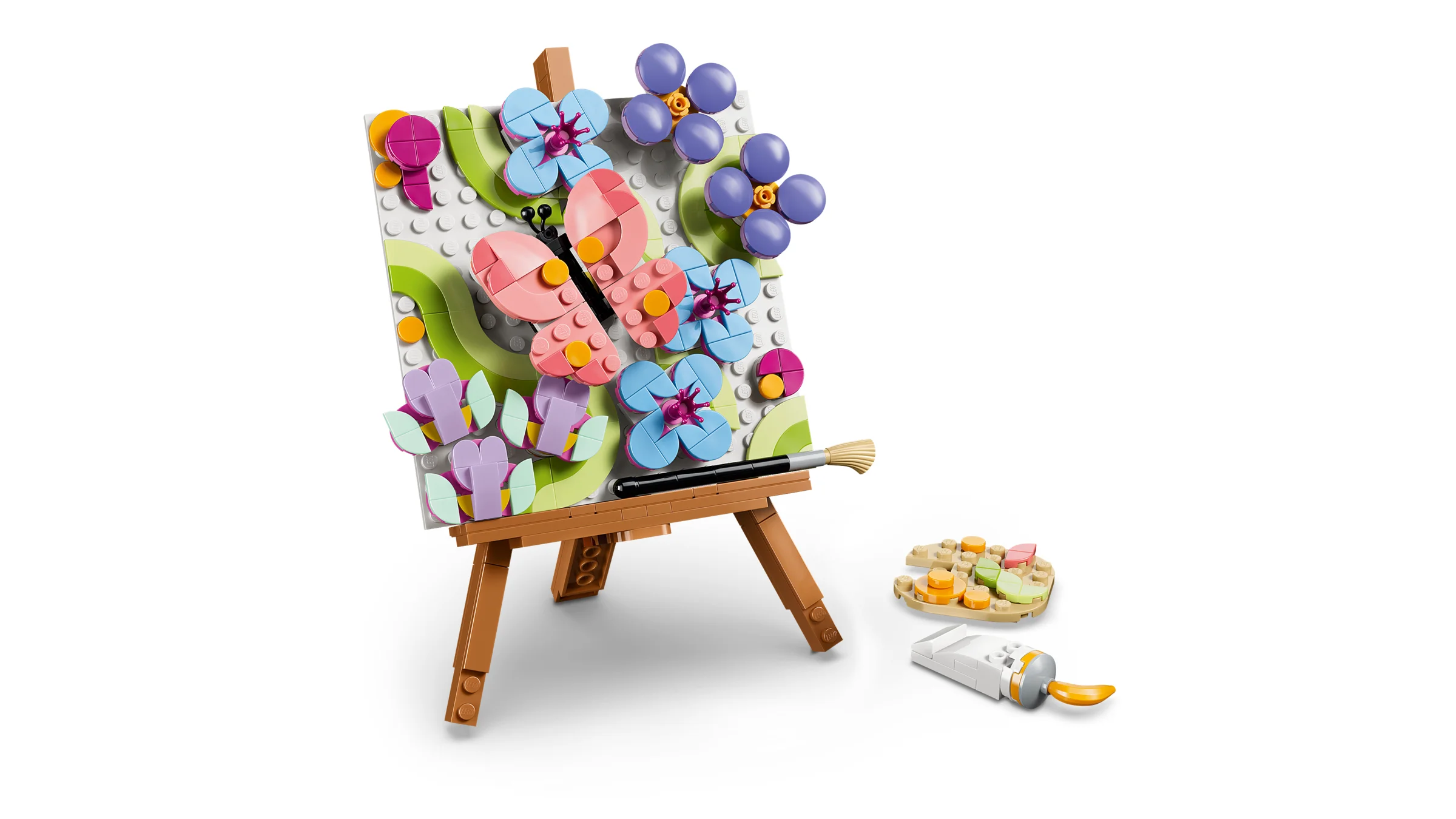 Pictură florală LEGO pe șevalet, cu flori, fluture, pensulă și paletă.
