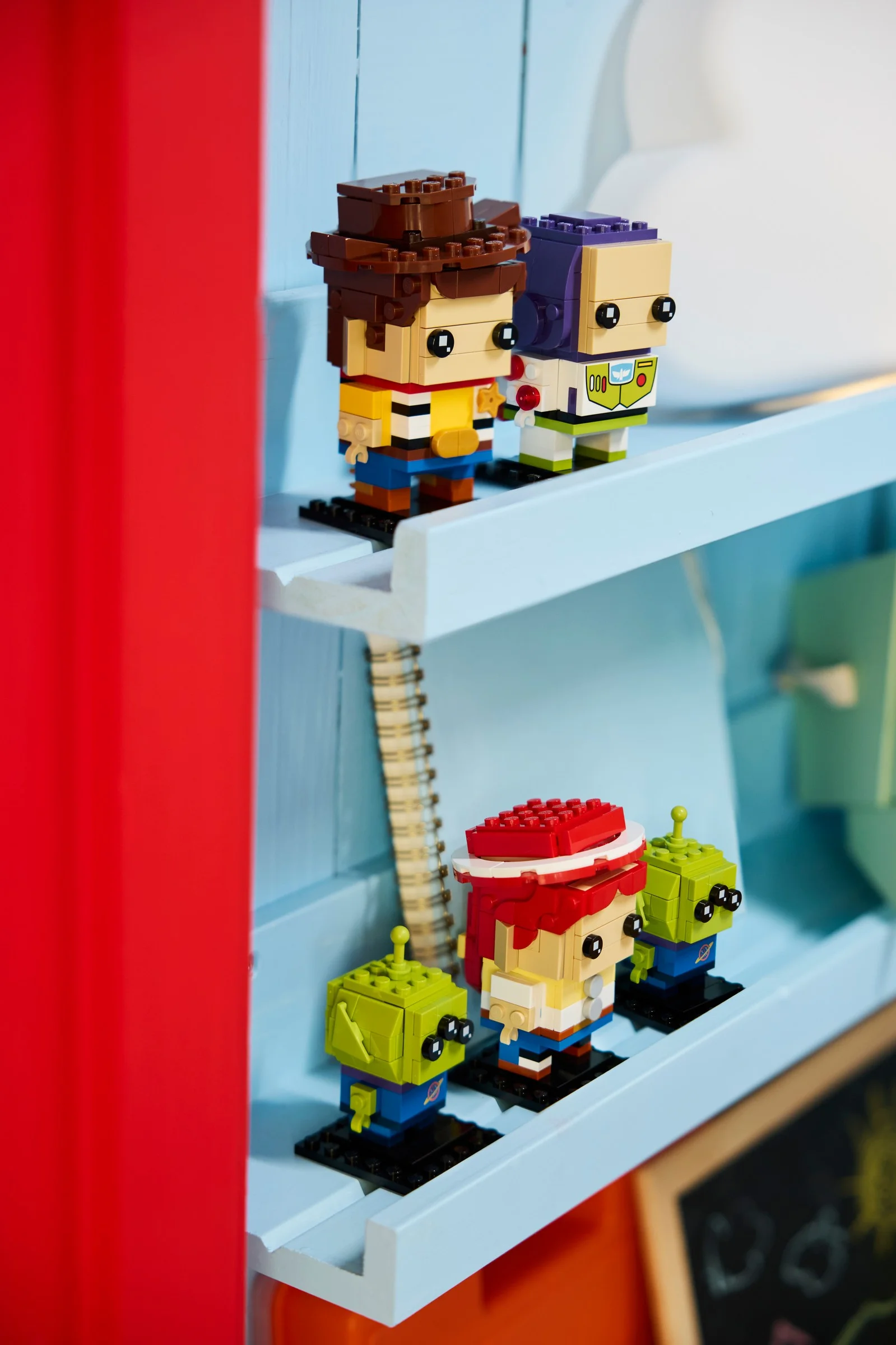 Setul LEGO BrickHeadz Toy Story, cu Woody, Buzz și extratereștrii verzi, expus pe un raft.