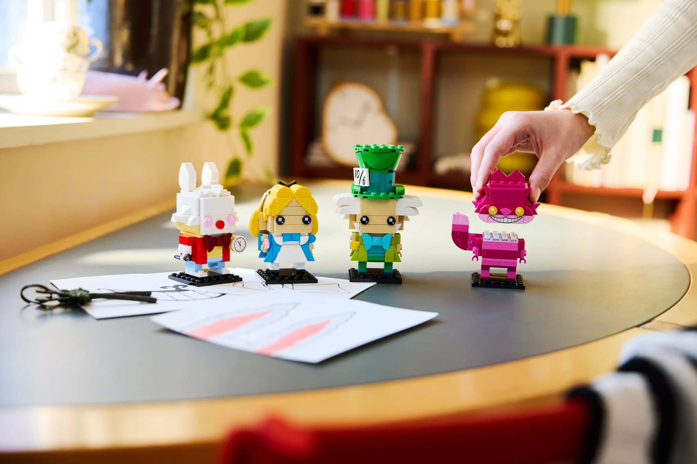 Imagine cu minifigurinele BrickHeadz Alice în Țara Minunilor: Iepurele Alb, Alice, Pălărierul Nebun și Pisica Cheshire.