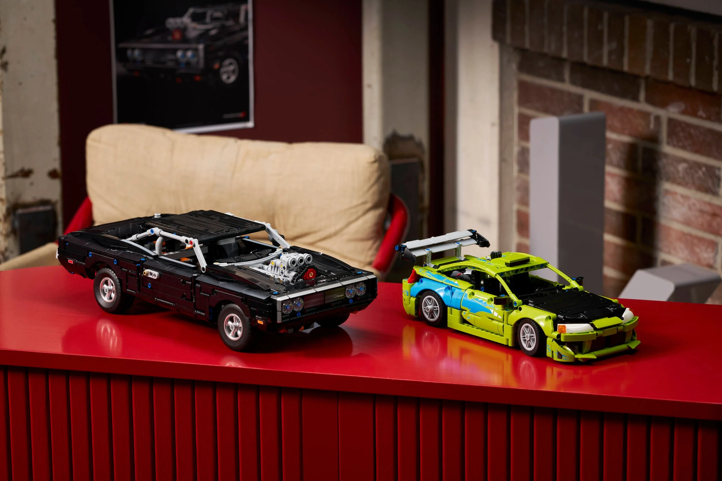Două mașini LEGO, un Dodge Charger negru și un Mitsubishi Eclipse verde, într-un decor de interior.