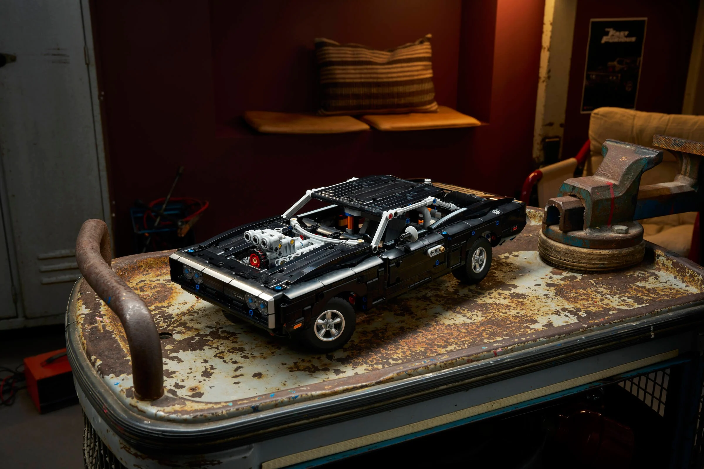 Dodge Charger R/T LEGO Technic 42231, model negru pe o masă ruginită într-un atelier.