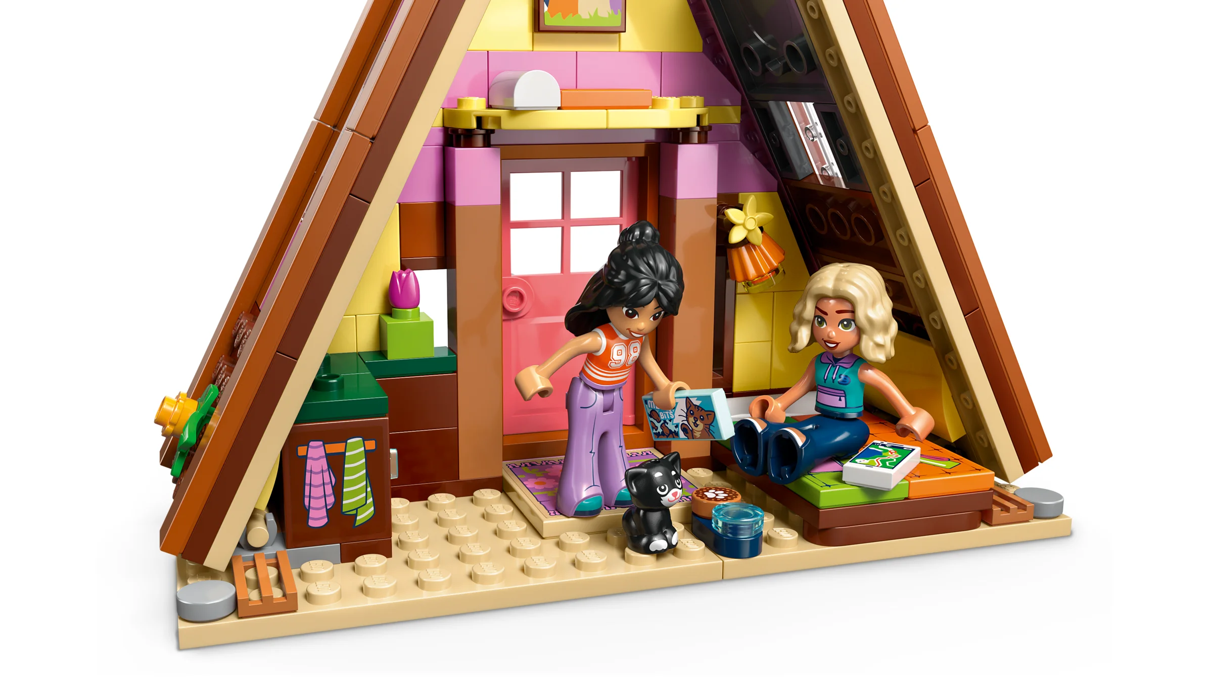 Cabină de glamping primitoare, cu două minifigurine și o pisică neagră.