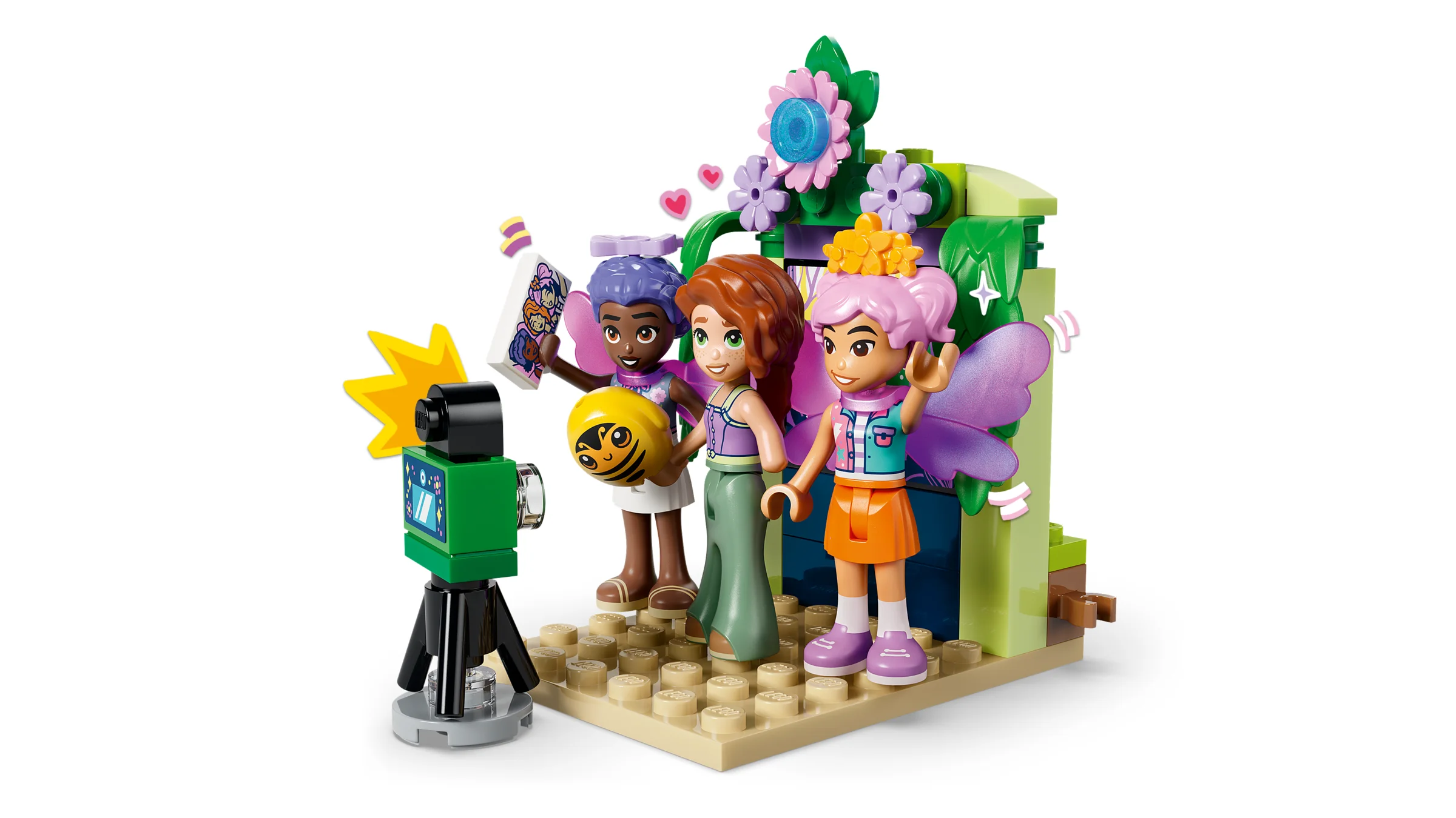 Prezentare cu 3 figurine zâne LEGO Friends, pozând pentru o fotografie într-un decor floral.