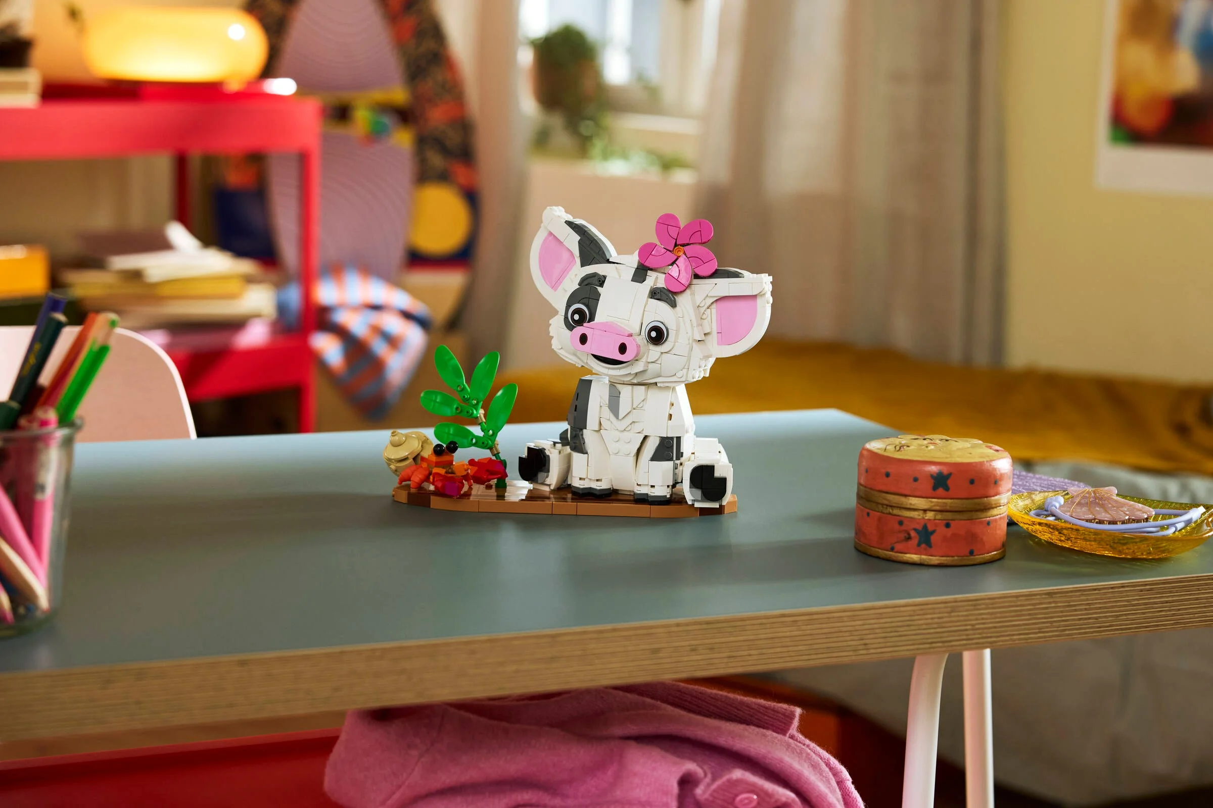 Pua LEGO, adorabil și detaliat, stând pe o bază cu decorațiuni tropicale.