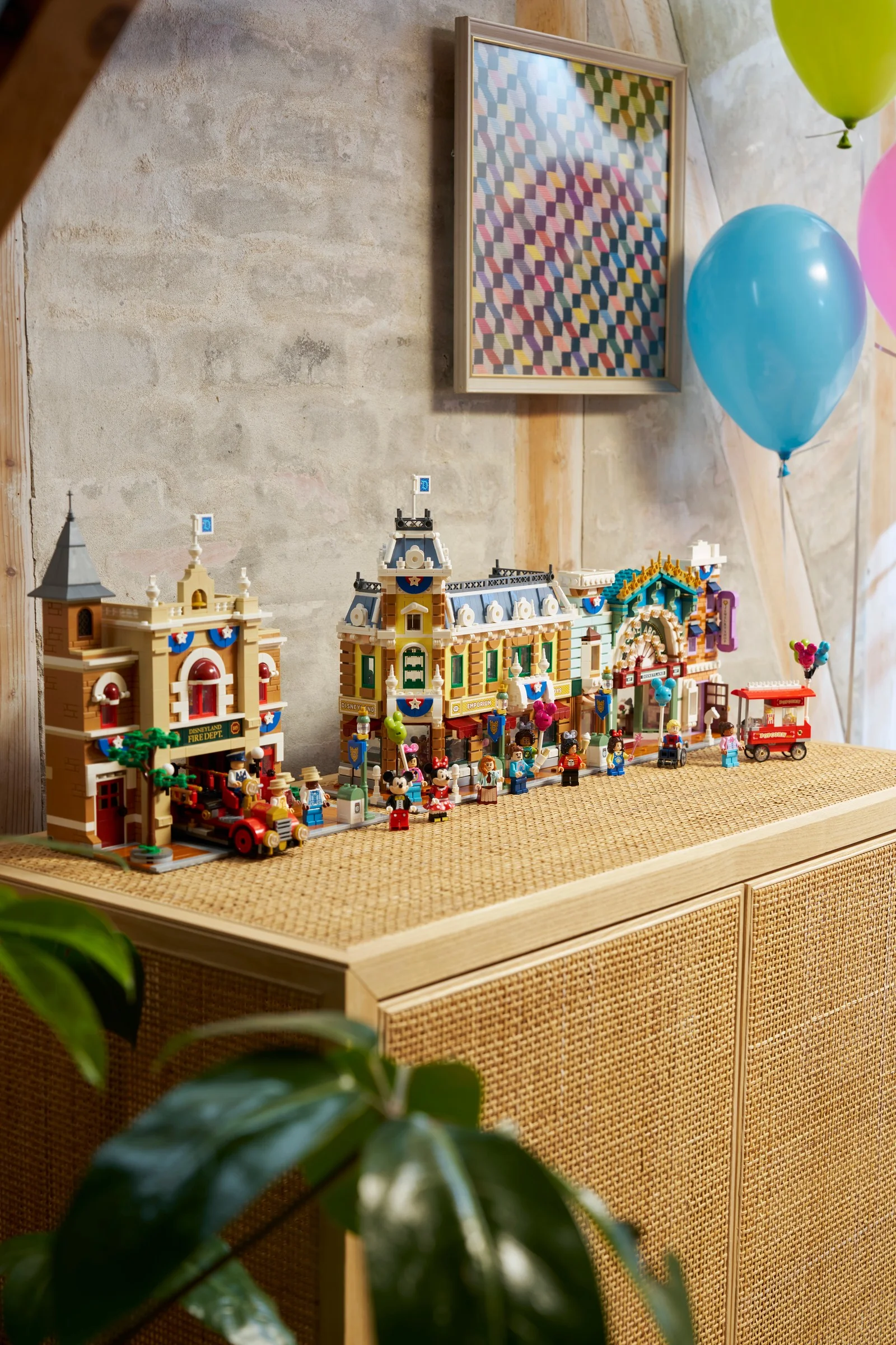 Imagine cu setul LEGO 43302 Main Street, U.S.A. aranjat pe o masă, cu minifigurine și detalii.