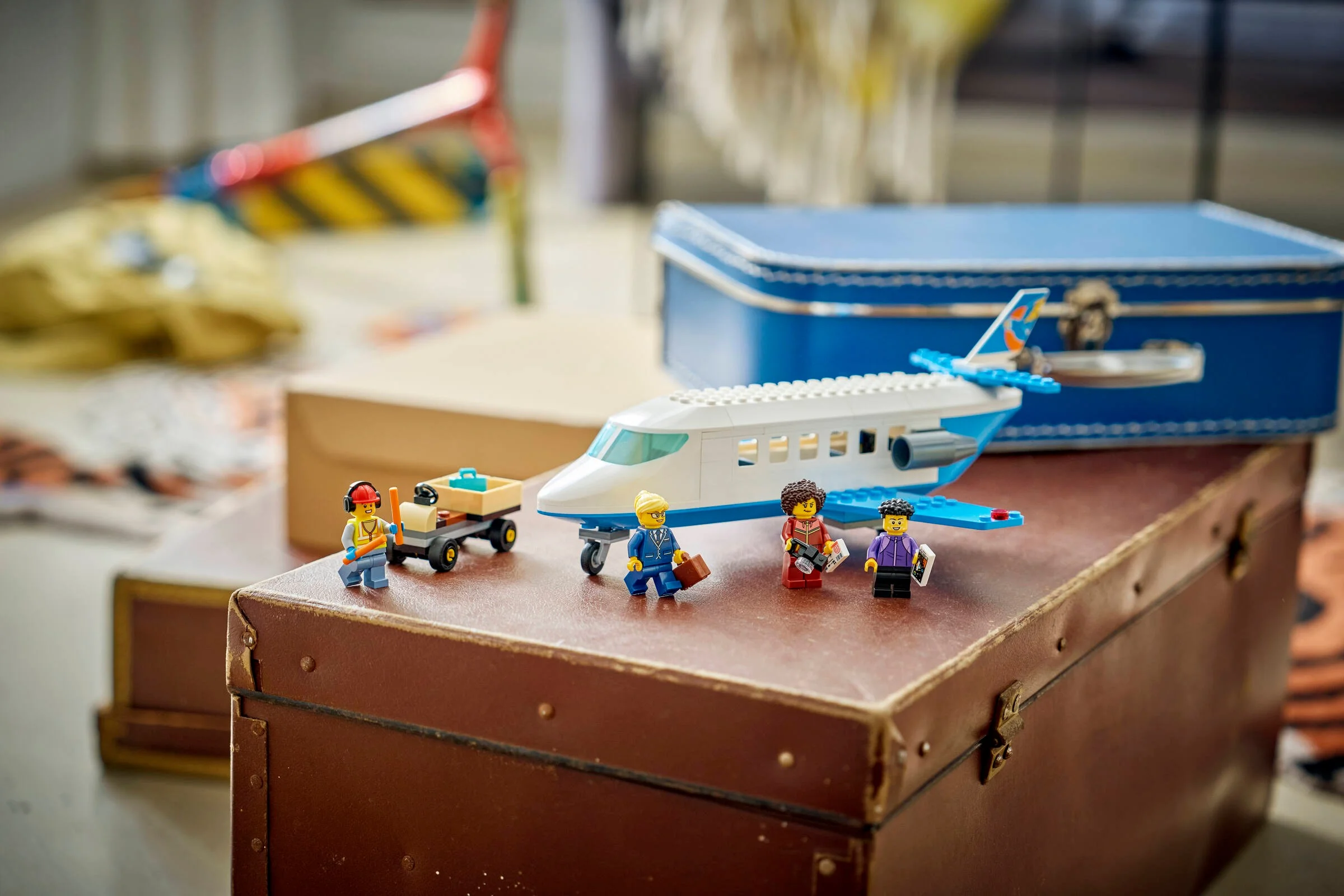 Avion de pasageri LEGO City 60492 și minifigurinele sale pe un fundal jucăuș.