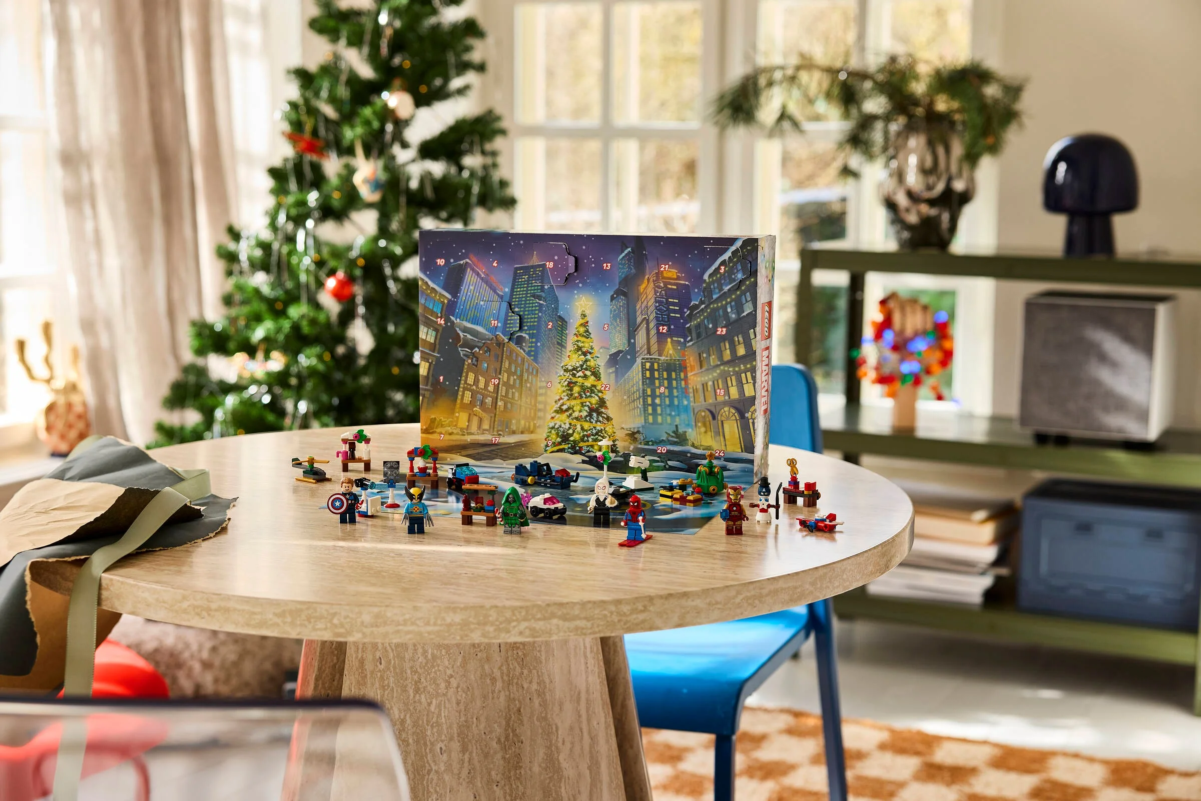 Imagine cu cutia Calendarului Advent Marvel 2026 și minifigurinele LEGO scoase pe masă.