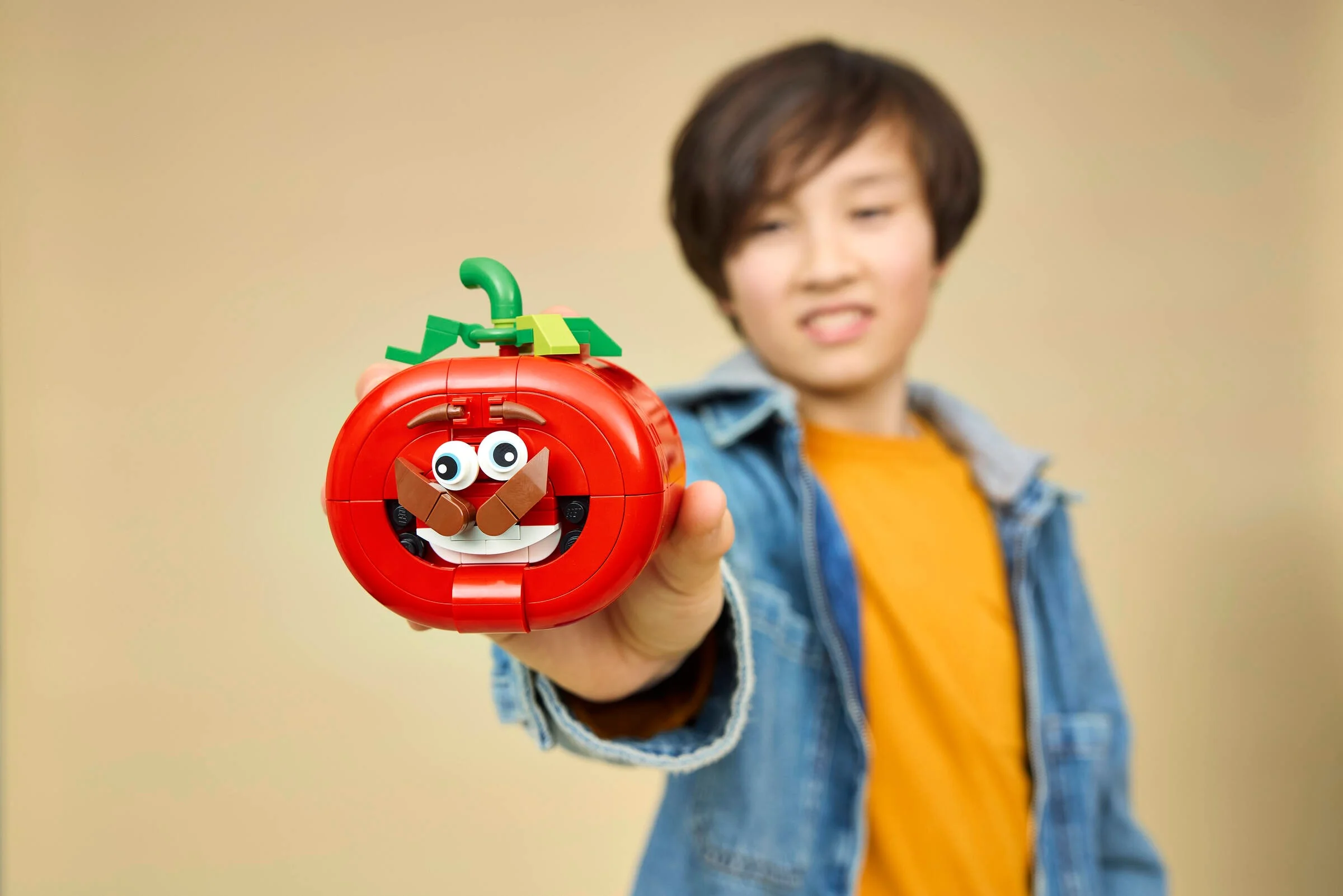 Un copil prezintă setul LEGO Tomatohead, o figurină haioasă.