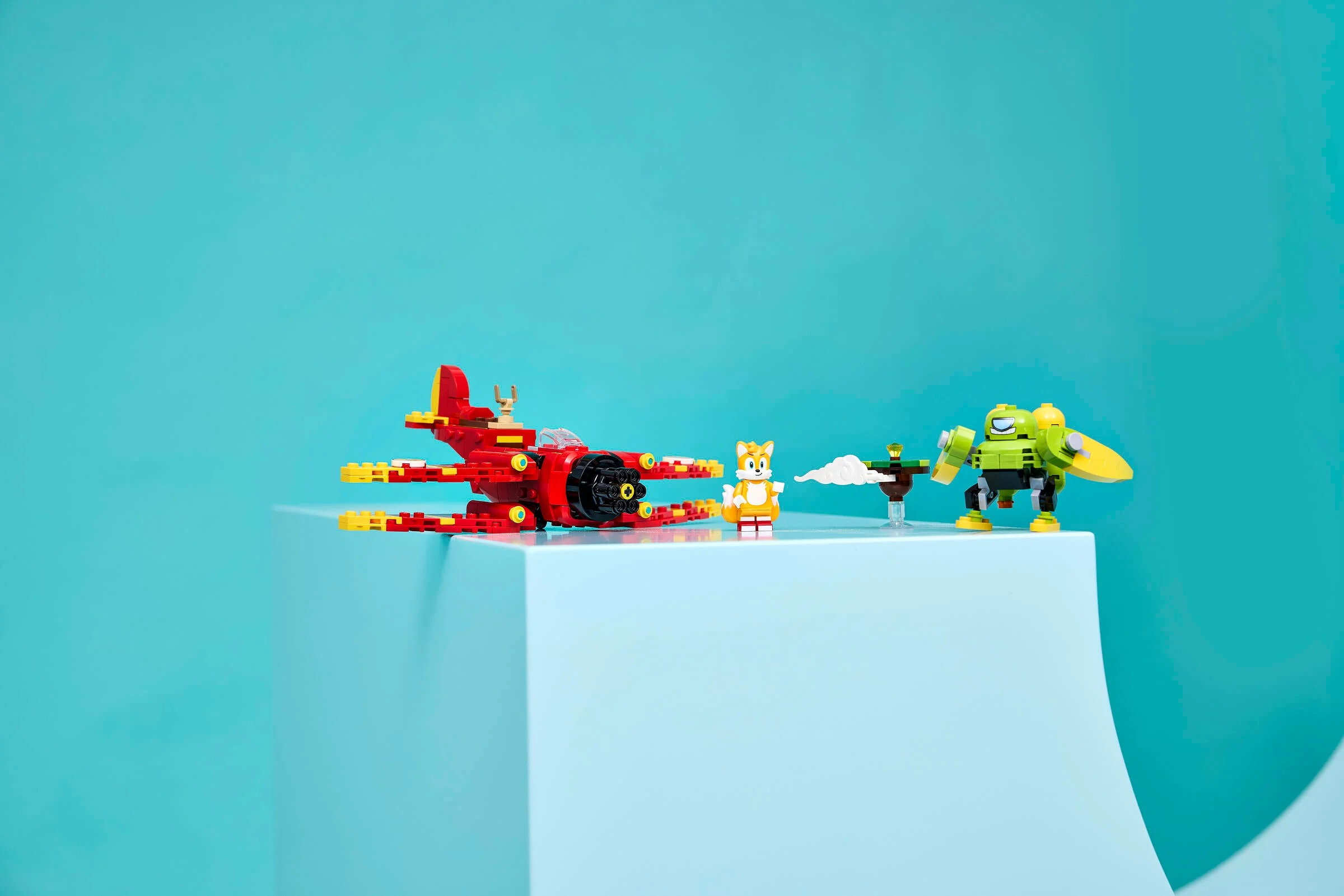 Avionul Tornado-1 al lui Tails, minifigurina Tails și robotul Badnik prezentate pe un fundal albastru.