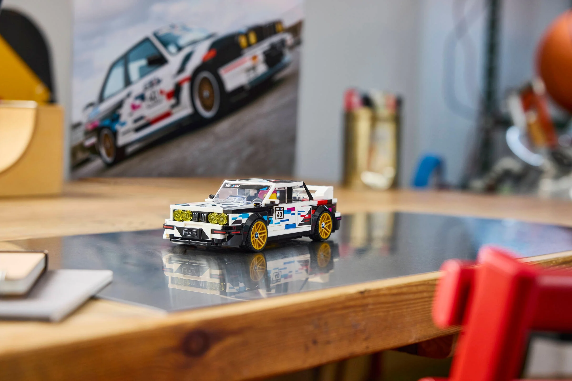 Prezentare LEGO BMW M3 (E30), set detaliat cu design sportiv și accente galbene. Mașină albă cu numărul 40.