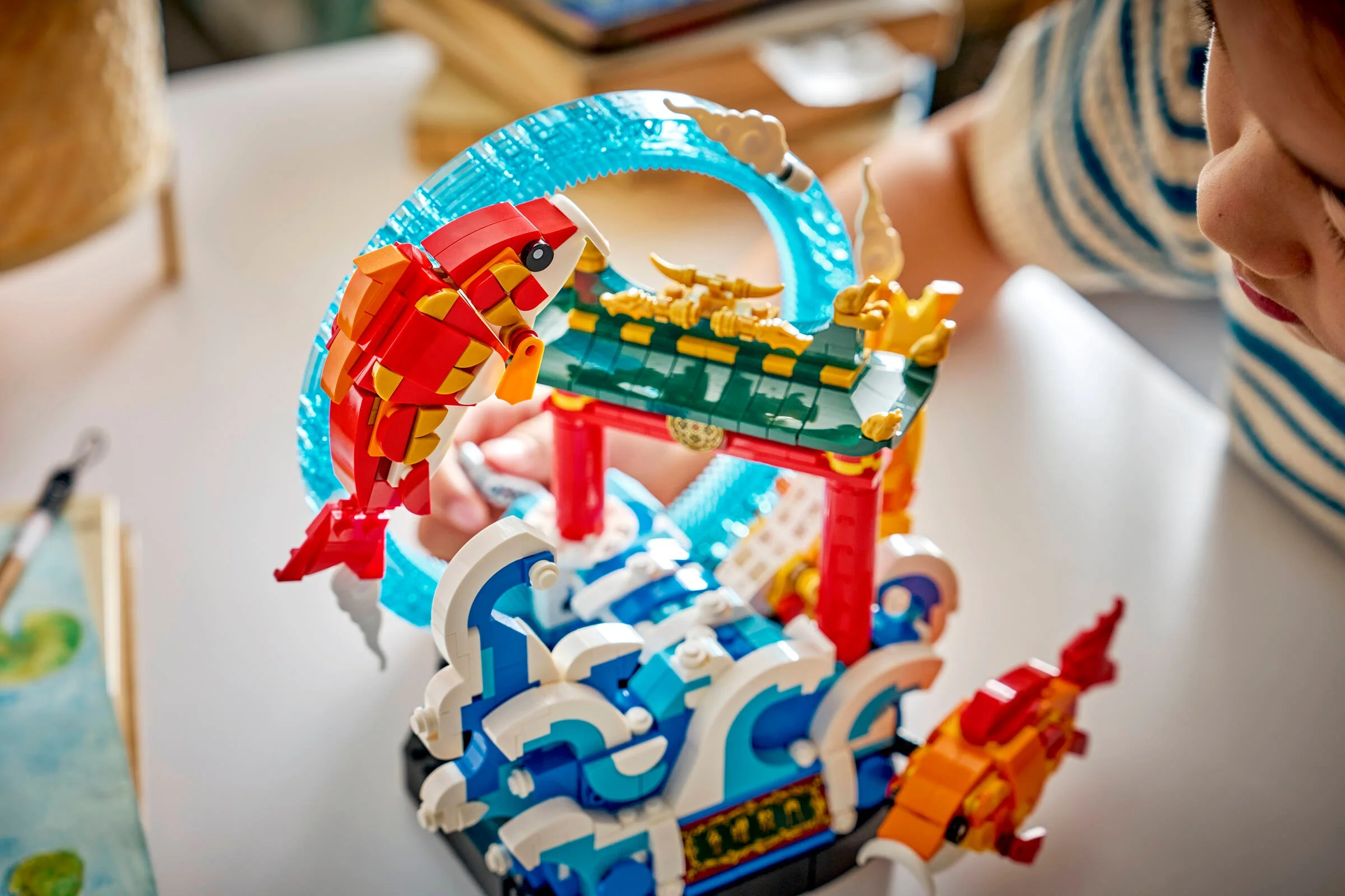 Carpă LEGO prosperă, cu detalii viu colorate, privită de aproape de un copil.
